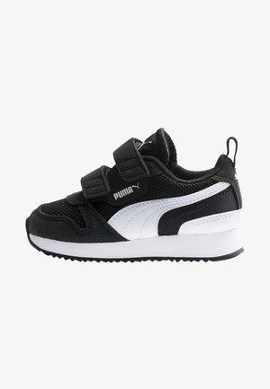 Baskets Puma noir et blanc avec deux bandes velcro, tige en mesh et en suède, bande Puma blanche et semelle épaisse blanche avec grip noir.