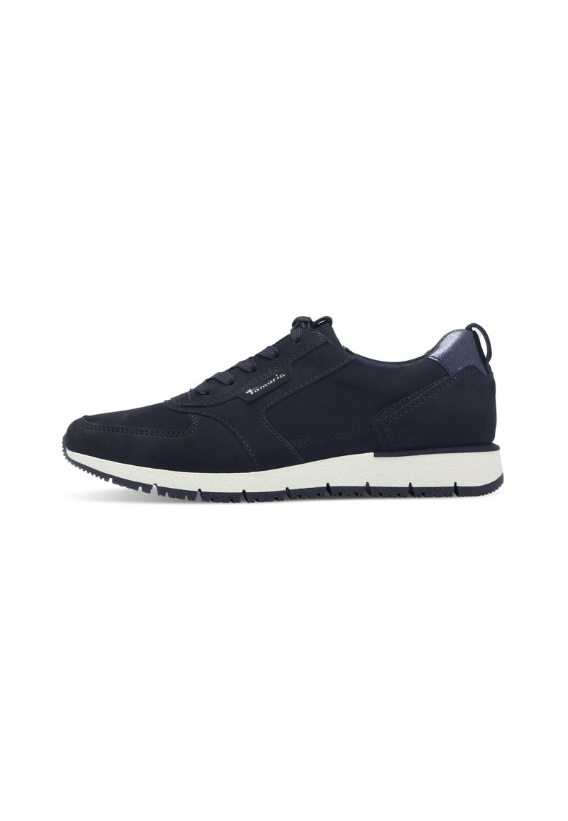 Chaussure de sport bleu marine avec une finition en daim lisse, semelle en caoutchouc blanc, lacets à l'avant et subtils accents métalliques sur le talon.