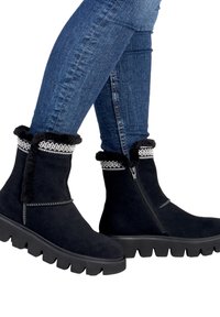 Botines de ante negro con borde de pelo sintético y costuras decorativas, con cremallera lateral y suela de goma gruesa.