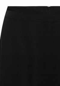 Jupe noire avec une texture lisse, dotée d'une fermeture éclair dissimulée à l'arrière et d'une taille élastique pour un ajustement confortable.