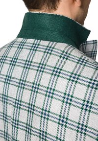 Zielono-biała kurtka w kratę z wysokim kołnierzem, teksturowana tkanina i kontrastujący zielony detal kołnierza. Dopasowany krój, widoczne akcenty szwów.