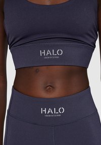Marine sportbeha met ronde halslijn en brede onderband, voorzien van het "HALO"-logo en nummers. Glad, rekbaar materiaal en een aansluitend ontwerp.