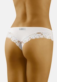 Witte onderkleding met kantafwerking, gemaakt van een gladde stof. Voorzien van een label op de tailleband en delicate bloemenkantaccenten langs de randen.