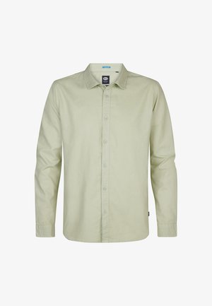 Chemise vert clair à manches longues, boutonnée sur le devant, col pointu, texture douce, avec une étiquette près de l'ourlet inférieur.