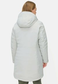 Lichtgrijze geïsoleerde parka met een capuchon, voorzien van een gladde textuur en naaddetailing, die voorbij de heupen valt voor extra warmte.