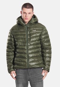 Olive zielona kurtka puchowa z zamkiem błyskawicznym z przodu, kapturem i pikowanym wzorem. Charakteryzuje się błyszczącym wykończeniem oraz logo "PROSTO" na piersi.