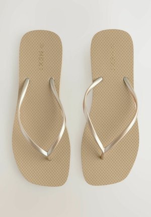 Beige flip-flops med en tekstureret sål og metallic sølv stropper. Simpelt design, der har en flad og bred sål for komfort.