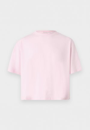 Vaaleanpunainen, lyhythihainen, pyöreäkauluksinen lyhyt t-paita, rento istuvuus, esillä yksinkertaisella vaaleanharmaalla taustalla.