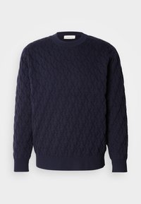Granatowy sweter dzianinowy z wzorkiem teksturowym, z okrągłym dekoltem oraz ribbami na mankietach i dolnej krawędzi. Minimalistyczny design bez widocznych logo.