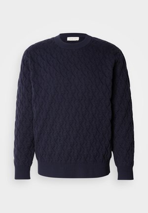 Marinblå stickad tröja med ett strukturerat mönster, med rund halsringning och ribbad mudd och nederkant. Minimalistisk design utan synliga logotyper.