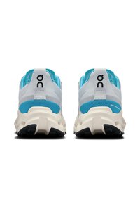 Herren-Sportschuhe mit einem grauen Mesh-Obermaterial, blauen Akzenten und einer weißen Zwischensohle. Bemerkenswerte Merkmale sind ein Logo an der Ferse und eine strukturierte Außensohle.