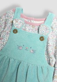 Ljusblå kordflorsklänning med en blommönstrad långärmad skjorta under. Har broderat kaninansikte, rundade axeldetaljer och träknappar.