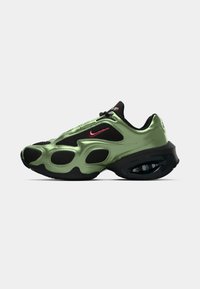 Light green synthetic sneaker with black mesh accents, thick sole, visible air cushioning, and red Nike swoosh logo on the side.