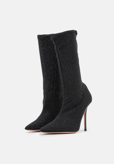 Black high-heeled boots featuring a textured upper with studded accents, pointed toe, and a fitted design for a sleek appearance.