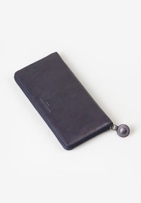 Portafoglio in pelle blu navy con chiusura a zip e tiretto tondo. Texture liscia e design minimalista. Forma rettangolare compatta.