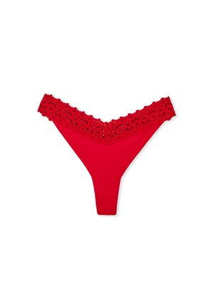 Slip rosso con bordatura in pizzo scallop e corpo in tessuto liscio. Il design prevede una copertura minima e una texture morbida.