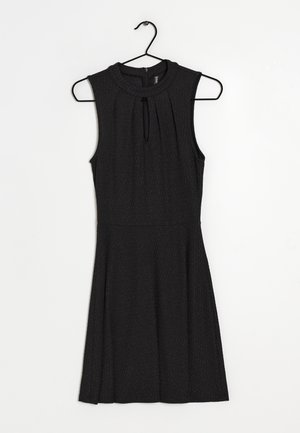 Schwarzes ärmelloses Kleid mit hohem Kragen, gefaltetem Detail vorne, ausgestelltem Rock und glatter Textur. Hängt an einem schwarzen Haken.
