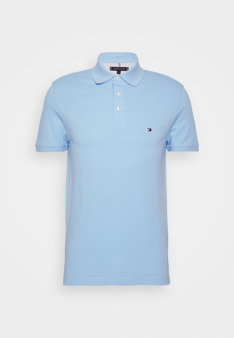 Polo bleu clair à manches courtes avec col, trois boutons blancs et un petit logo sur la poitrine gauche.