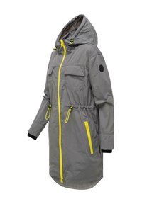 Sivi kabanica s kapuljačom, žutim patentnim zatvaračem i ukrasima na džepovima, podesivim vezicama u struku i dugim rukavima s unutarnjim crnim manšetama.