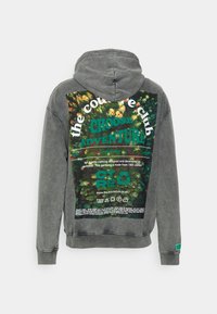 Sudadera de algodón gris con un gran estampado gráfico en la parte posterior que presenta texto verde y un diseño inspirado en la naturaleza. Incluye una capucha con cordón.