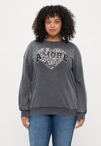 Sweatshirt cinza com um coração em padrão de leopardo e texto "AMORE". Apresenta um decote redondo e punhos canelados, feito de um tecido suave.