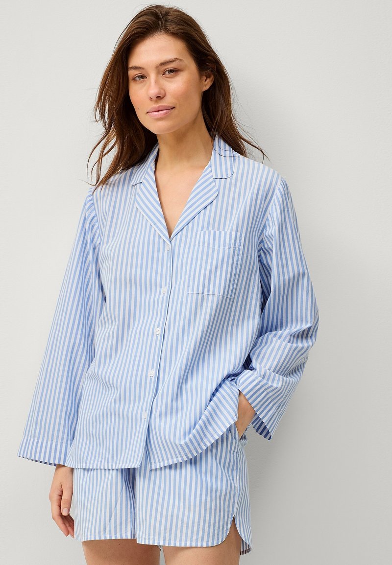 Blå og hvid stribet pyjamassæt med en langærmet skjorte med knaplukning og lomme samt matchende shorts med sideslit. Blød stofstruktur.