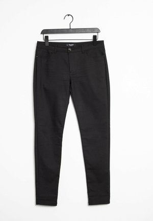 Jean skinny noir avec une texture lisse, présentant une fermeture à bouton et à zip à l'avant, des poches latérales et des détails de couture le long des coutures.