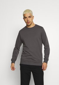 Grå genser med rund hals laget av mykt stoff, med ribbede mansjetter og nederkant, i normal passform og uten synlige mønstre.