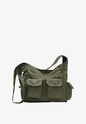 Zielona oliwkowa torba na ramię z płótna o sztywnym fasonie, z dwoma przednimi kieszeniami na klapę, regulowanym paskiem oraz boczną kieszenią na zamek.