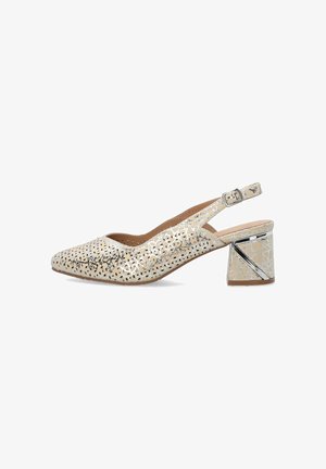 Beige slingback schoen met perforatie in bloemmotief, vierkante neus, verstelbare gesp en blokhak met metallic zilverkleurige accent.