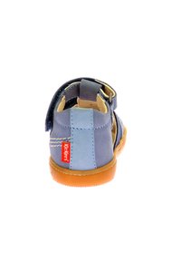 Sandalia de cuero en tonos azules con suela de goma color marrón. Presenta una correa ajustable y el logo de Kickers en el talón. Diseño de espalda abierta para mayor transpirabilidad.