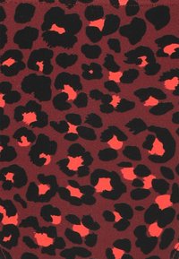 Leopardmönstrad tyg i svart och korall på en mörk vinröd bakgrund. Slät textur med oregelbundna mönstelement i varierande storlekar.