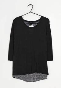 Maglietta nera a maniche lunghe con scollo rotondo, caratterizzata da uno strato interno a motivo esagonale bianco contrastante all'orlo. Tessuto dalla texture liscia.