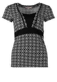 Haut à manches courtes à motifs noir et blanc avec un col en V, un accent noir uni à la taille et une texture lisse et douce.