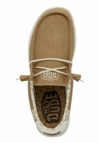 Zapato de lona color marrón claro sin cordones, con suela blanca y encaje decorativo. La plantilla de corcho presenta un patrón de logo en contraste.