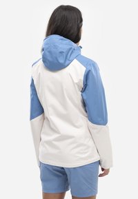 Leichtgewichtige, zweifarbige Jacke in Weiß und Hellblau, mit Kapuze, langen Ärmeln und einer glatten, wasserabweisenden Textur.
