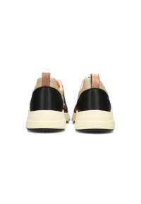 Vue arrière de baskets avec tige en cuir noir et mesh beige, semelle en caoutchouc crème et languette beige. Accents texturés et contraste de couleurs.