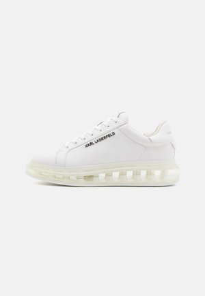White leather sneakers with a translucent sole, highlighted by the brand name "KARL LAGERFELD" in metallic lettering on the side.