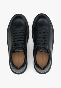 Czarne skórzane sneakersy o gładkim wykończeniu, okrągłym nosku i sznurowanej konstrukcji. Zawierają subtelne logo na języku oraz teksturowane podeszwę.