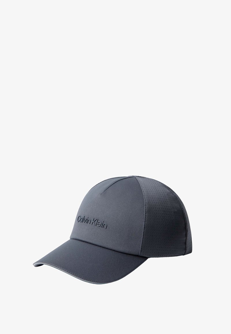 Casquette de baseball Calvin Klein gris foncé avec une visière courbée et des panneaux latéraux perforés pour la ventilation sur fond blanc.