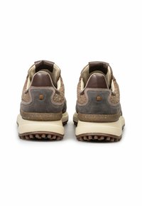Ruskeat ja beige lenkkarit, joissa on teksturoitu päällinen, mokkanahkaosuuksia ja kookas pohja, jossa on kumiset pito-ötökät ja logo-yksityiskohta.