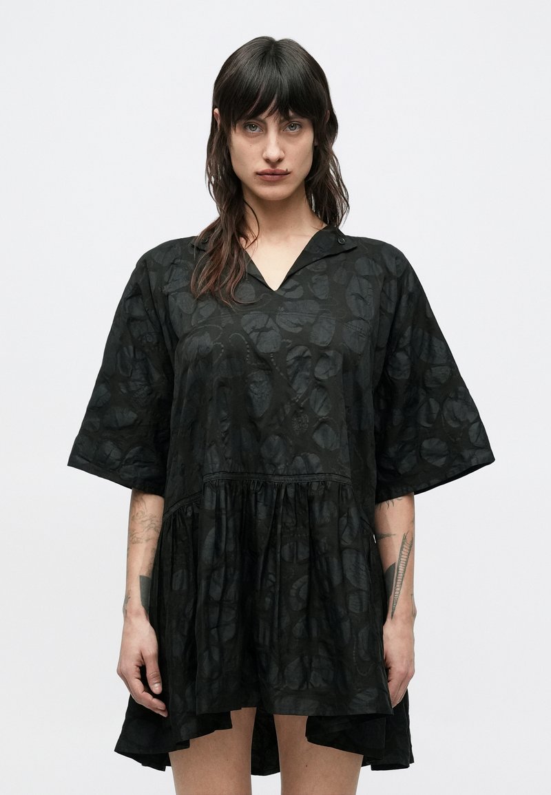 Μαύρο φόρεμα με V-λαιμόκοψη και κον τά μανίκια, με υφή και στρωματοποιημένη βάση. Κατασκευασμένο από ελαφρύ ύφασμα.