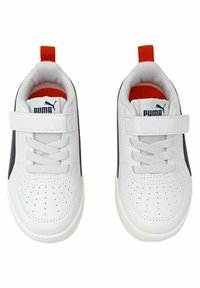 Zapatillas deportivas blancas con una superficie texturada, que cuentan con una correa de velcro y cordones. Acabadas con una franja lateral en color marino y una lengüeta en color rojo en el talón.