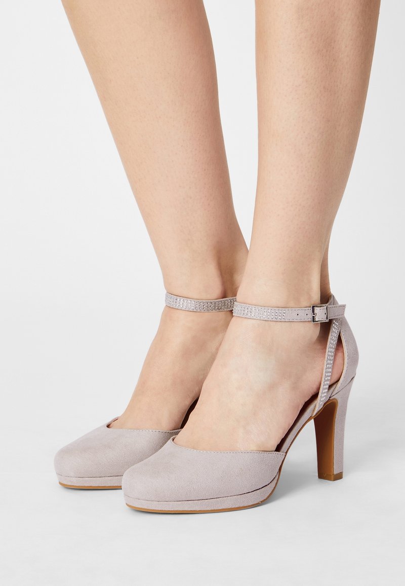 Chaussures à talons hauts en daim gris avec une bride à la cheville, présentant une finition lisse et un bout arrondi, montées sur un talon en bois effilé.