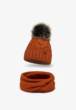 Bonnet en tricot orange avec un pompon en fourrure et une écharpe infinity assortie, tous deux présentant un motif texturé.