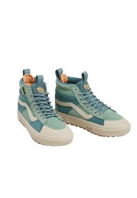 Wysokie sneakersy w jasnym niebieskozielonym zamszu z kremową gumową podeszwą, wyściełanym kołnierzem oraz niebieskimi sznurówkami i pomarańczową metką wewnątrz.