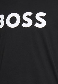 Schwarzes Baumwoll-T-Shirt mit auffälligem weißen "BOSS"-Text über der Brust; weicher Stoff mit klassischem Rundhalsausschnitt.