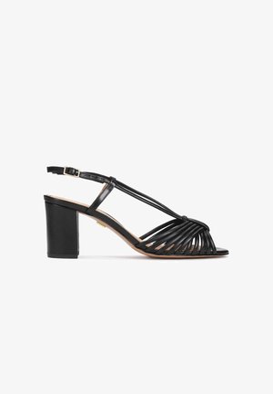 Sandalo con tacco alto in pelle nera con cinghie sottili che formano un design intrecciato. Presenta una fibbia regolabile alla caviglia e un tacco chunky.