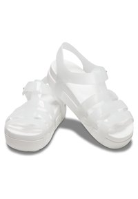 Vita jelliskor med ett snoddmönster, slät textur och en plattformsula. Har justerbar vristrem och perforerad fotsäng.