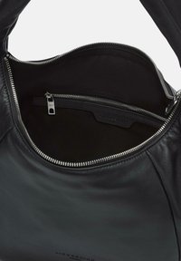 Borsa a tracolla in pelle nera con apertura con cerniera, caratterizzata da una superficie liscia, una tasca laterale e un design semplice. L'interno è in tessuto scuro.